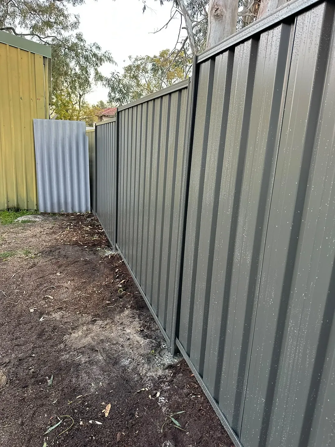 Grey Colorbond fence following a narrow residential boundary