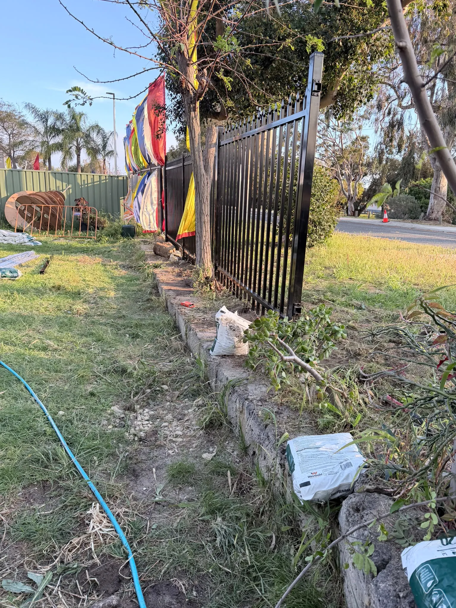 Garrison fencing installation beside established trees and vegetation in Wanneroo